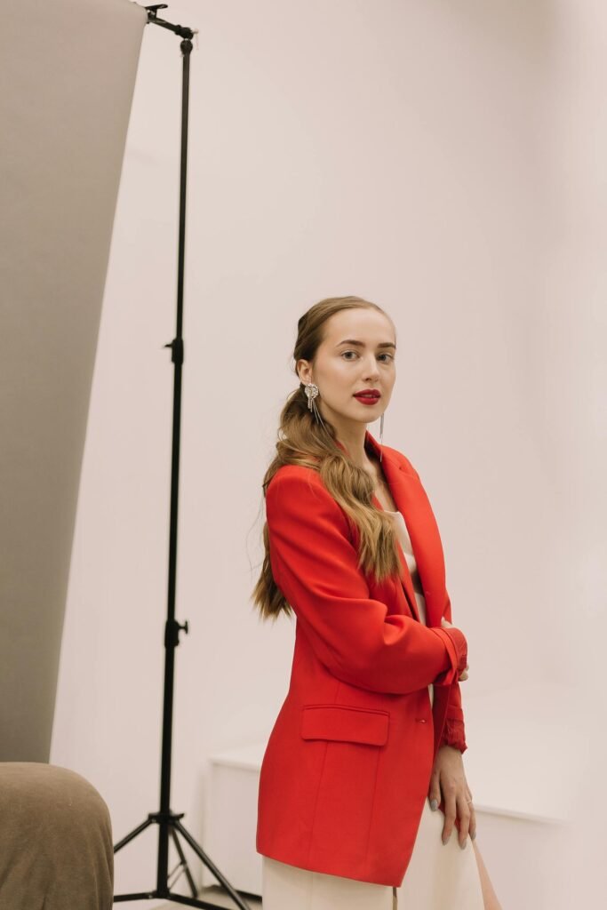 Model in a layered linen coat against a chalky stone wall